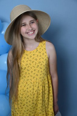 Mavi arka planda şapkalı sarışın kız.,