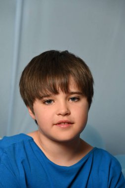 Mavi arka planda yakışıklı bir çocuk,
