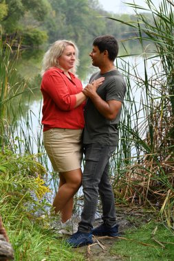 Ormandaki nehirde duran kadın ve erkek. 