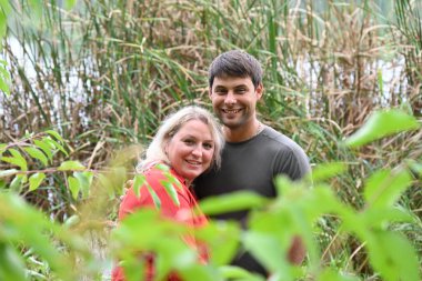 Yeşil ormanda kucaklaşan bir çift.