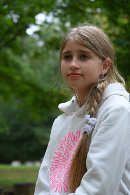 Sarışın kız parkta vakit geçiriyor. 