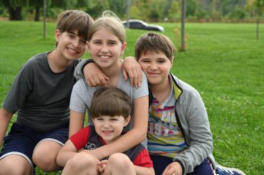 Çimenlerin üzerinde oturan çocuk