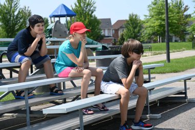 Çocuklar stadyumun merdivenlerinde oturuyorlar.,