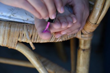 Kız tırnaklarını pembe cila ile boyuyor.