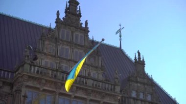 Bremen 'deki bir binada Ukrayna bayrağı. Üzerinde Ukrayna bayrağı olan ünlü Alman şehrinin ana meydanı. 4k UHD