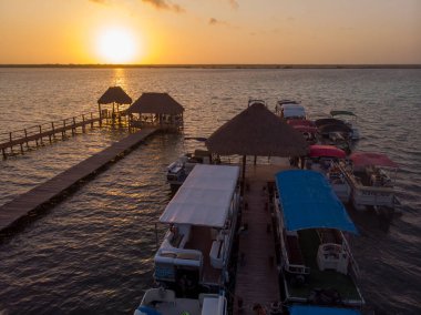 Sakin Meksika kasabası Bacalar 'da gün doğumu, Quintana-Roo, Meksika' da sabah vakti. Lagoon 'da botları olan bir sütundaki rıhtımlar. Havadan