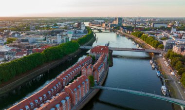 Bremen, Almanya. Bremen şehrinin hava görüntüsü, günbatımında Weser nehrinin üzerinde İHA uçuşu. 4k, 5k UHD 'den düşür