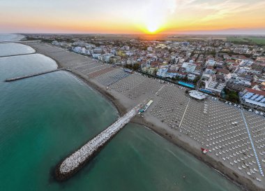 Gün batımında İtalya, Venedik 'teki Caorle sahilinin insansız hava aracı fotoğrafı. County Resort Town 'daki şemsiyeler. Yüksek kalite fotoğraf