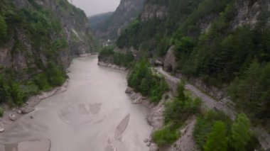 Dağlardaki terk edilmiş bir yoldaki insansız hava aracının hava görüntüsü. Bir dağ sırasının kayalık bir bölümünde eski bir harabe yol. Yüksek kalite 4k görüntü