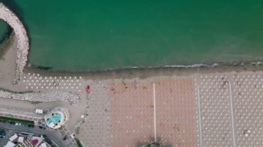 Venedik yakınlarındaki tatil köyü sahil kentinde bir Caorle 'un hava görüntüsü. Adriyatik Denizi 'nin gün batımında bir plajı. 4k UHD Drone Videosu