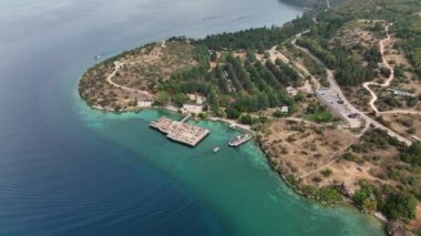 Göl kıyısında Açık Hava Müzesi. Sudaki eski otantik ahşap evler. Kuzey Makedonya 'da, Ohri Gölü' nde, Bay on Bones etrafında insansız hava aracı uçuşu. İnsansız hava aracı videosu. Yüksek kalite 4k görüntü