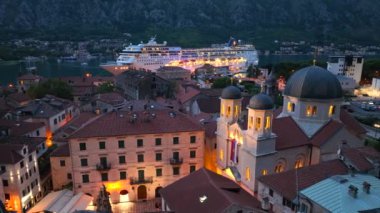 Karadağ 'daki Aydınlanmış Kotor eski kasabasının gece hava aracı görüntüsü. Harbour 'daki Big Cruise Gemisi, yolcu gemisi. Yüksek kalite 4k görüntü