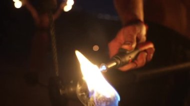Ateş gösterisi gösterisi gösterisi. Yakışıklı erkek ateş hokkabazı birkaç değnek ve değnekle temas manipülasyonu yapıyor. Yakın plan. Ağır çekim. Yüksek kalite 4k görüntü