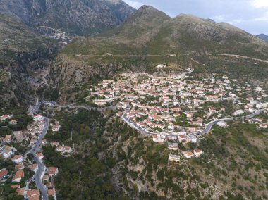 Gün batımında Dhermi. Güzel Köy Deniz Manzarası 'nın Hava Çekimi, Taş Evler, Arnavutluk Dağları' ndaki plaj Resort 'u. 4k Yüksek Kaliteli Drone Görüntüsü
