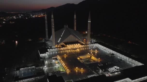 夜のイスラマバードのファイサル マスジド パキスタン最大のモスクが照らされています ドローンショット エアリアル 高品質の4K映像 — ストック動画