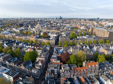 Hollanda, Amsterdam 'ın Tarihi Merkezi. Dar sokaktaki ve kanaldaki geleneksel Hollanda evlerinin insansız hava aracı görüntüleri. 4k UHD, 5k video