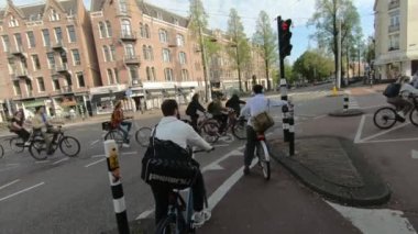 Amsterdam, Hollanda - 3 Mayıs 2024: Bisiklet dostu Amsterdam 'da POV bisiklet sürüşü yapan ilk kişi. Yüksek kalite 4k görüntü