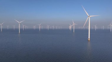 Flevoland Hollanda 'daki IJsselmeer Gölü' ndeki yel değirmeni parkı, Denizdeki Offshore Wind Türbines Windmill Çiftliği, Sunset. Yüksek kalite 4k görüntü