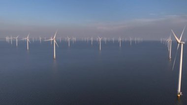 Flevoland Hollanda 'daki IJsselmeer Gölü' ndeki yel değirmeni parkı, Denizdeki Offshore Wind Türbines Windmill Çiftliği, Sunset. Yüksek kalite 4k görüntü