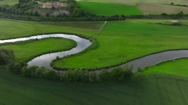 Bavyera 'da küçük kıvrımlı bir nehir. CUte Tine nehrinin akşam ışığında S eğrisiyle havadan drone çekimi. Almanya. Yüksek kalite 4k görüntü