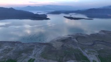 Khanpur Barajı Havadan Günbatımı Manzarası, Pakistan. Sudaki tekneler ve arka plandaki dağlar. Yüksek kalite 4k görüntü