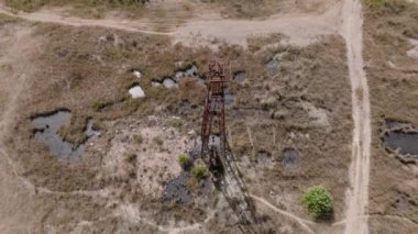 Güneşli bir günde Albaina 'da eski paslı petrol kuyusu Jack Field' ı pompalıyor. Balkanlara Küçük Ev Yapımı Petrol Pompaları. 4k UHD