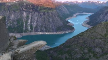 Trollgunga, gün doğumunda Troller dili, uçurumun üstündeki ünlü uçurum. Altında Blue Lake, Troll, Trolltunga, Norveç. Yüksek kalite 4k görüntü