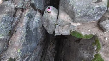 Kız Adventurist Norveç 'te Kjeragbolten' e atlıyor. Fjord Dağları 'ndaki Kjerag Kayası Hava Manzarası. 4k UHD