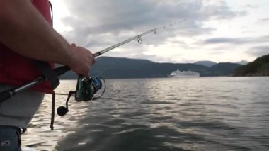Fjord 'da Balıkçılık. Adam Norveç 'te oltayla balık tutuyor. İskandinav fiyortlu tekne balıkçısı. Yüksek kalite 4k görüntü