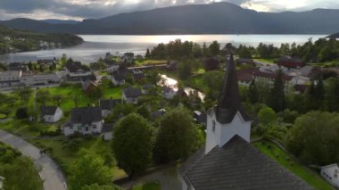 Fiyort kıyısındaki tipik Norveç Köyü, Sakin Deniz Üzerinde Yaz Akşamı Günbatımında Hava Dronu vuruldu. Yüksek kalite 4k görüntü