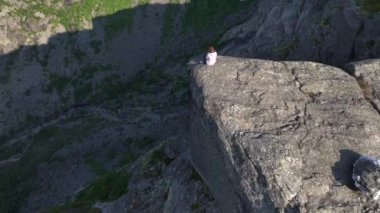 Norveç, Trolltunga 'da uçurumun kenarında bir kız. Norveçli Seyahat Uzmanı Gezgin Gezgin Gezgin Trol Dili 'nde Hava Aracı Atışı. Yüksek kalite 4k görüntü