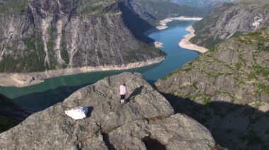 Maceracı Gezgin Kız Norveç Dağları 'ndaki uçurumun kenarına geliyor. Hava Atışı, Trol Dili, Norveç. Yüksek kalite 4k görüntü