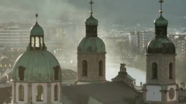Avusturya, Innsbruck 'taki St. James Katedrali' nin çan kuleleri. Foggy Evening 'in günbatımında Soaft Light' taki kilise kubbeleri. 4k UHD