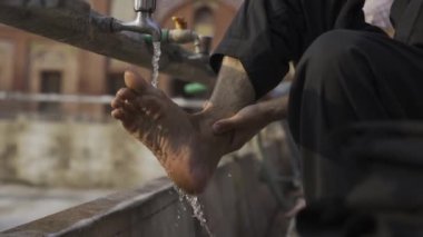 Müslüman adam Lahor, Pakistan ve Asyalı Müslümanlar 'daki camide namaz kılmadan önce ellerini ve ayaklarını yıkıyor. Ağır çekim. Yüksek kalite 4k görüntü
