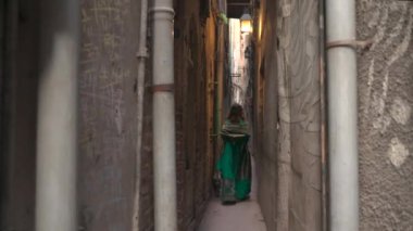 Güzel Yeşil Elbiseli Genç Müslüman Kadın Pakistan 'ın Lahore şehrindeki Dar Duvarlı Caddelerde yürüyor. Yüksek kalite 4k görüntü