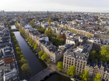 Hollanda, Amsterdam 'ın Tarihi Merkezi. Dar sokaktaki ve kanaldaki geleneksel Hollanda evlerinin insansız hava aracı görüntüleri. 4k UHD, 5k video