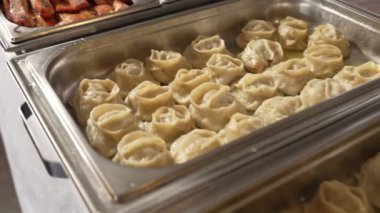 Yemek masasında açık büfe yemek, Manti yemeği, Somon, Sos, Fransız eti, Sebze, Pirinç. Yüksek kalite 4k görüntü