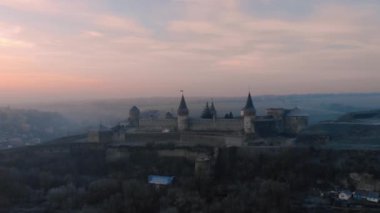 Ukrayna 'da, gün doğumunda Podilskyi Kalesi' nin üzerinde uçuyor. Kış 'taki bir ortaçağ şatosunun insansız hava aracı görüntüleri. Yüksek kalite 4k görüntü