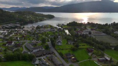 Fiyort kıyısındaki tipik Norveç Köyü, Sakin Deniz Üzerinde Yaz Akşamı Günbatımında Hava Dronu vuruldu. Yüksek kalite 4k görüntü