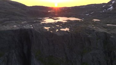 Troll Dili ya da Trolltunga 'nın bulunduğu Ringedalsvatnet Gölü üzerindeki Norveç Uçurumları. Gündoğumunda hava durumu. Yüksek kalite 4k görüntü