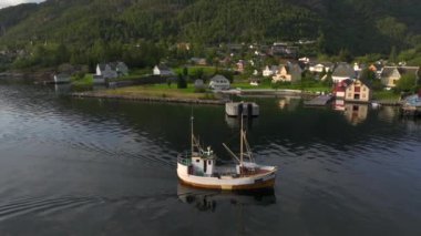 Jondal, Norveç - Ağustos 2024: Bir Küçük Balıkçı Gemisi Fjord 'un durağan bölgesinde yavaş hareket ediyor. Hava Akşamı Günbatımı Çekimi. Yüksek kalite 4k görüntü