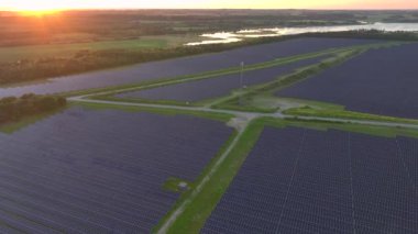 Photovoltaik Panelleri olan güneş enerjisini elektriğe çeviren bir güneş çiftliği. Günbatımında Danimarka 'da yeşil enerji. Havadan. Yüksek kalite 4k görüntü