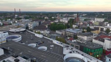 Essen, Almanya - 9.09.2024: Essen-Stadtkern, Limbecker alışveriş merkezinin çatısındaki otopark. Günbatımında Almanya 'da NRW şehrinin havacılığı. Yüksek kalite 4k görüntü