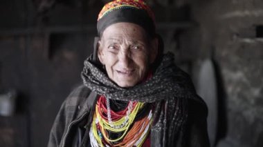 Kalash insanları. Bumburet Vadisindeki en yaşlı kadın, büyükanne Kalashi. Kış 'ta kulübesinde yaşlı bir kadın, Chitral, Pakistan. Yüksek kalite 4k görüntü