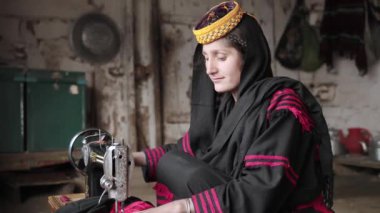 Genç Kalashi 'nin portresi, geleneksel olarak giyinmiş kız Kalash Vadisi, Chitral, Pakistan' da elbise dikiyor. Yüksek kalite 4k görüntü