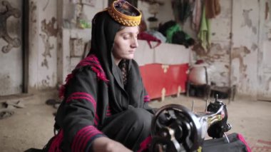 Genç Kalashi 'nin portresi, geleneksel olarak giyinmiş kız Kalash Vadisi, Chitral, Pakistan' da elbise dikiyor. Yüksek kalite 4k görüntü