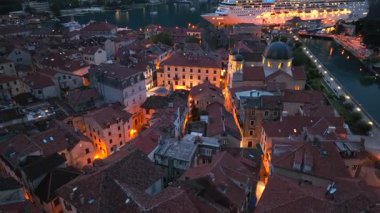 Karadağ 'daki Aydınlanmış Kotor eski kasabasının gece hava aracı görüntüsü. Harbour 'daki Big Cruise Gemisi, yolcu gemisi. Yüksek kalite 4k görüntü