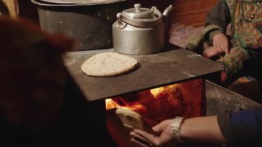 Kalash, Pakistan, Himalayalar 'da Chapati' yi Ateş Fırını 'nda yapan kadının elleri. Geleneksel Chapati 'nin kırsal yemekleri. Yüksek kalite 4k görüntü