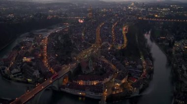 İsviçre 'nin Bern şehrinde Gece Alacakaranlığı' nın yukarısından aydınlandı. Başkent Akşam Manzarası. Hava aracı atışı. Yüksek kalite 4k görüntü