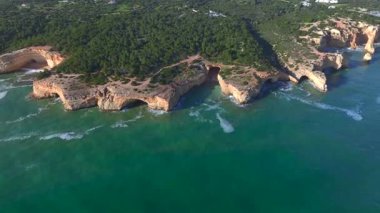 Marinha Sahili, Algarve, Güney Portekiz 'deki Doğal Kemer' in havadan görünüşü. Oyulmuş sahil şeridindeki kayalık yamaçlar. Yüksek kalite 4k görüntü